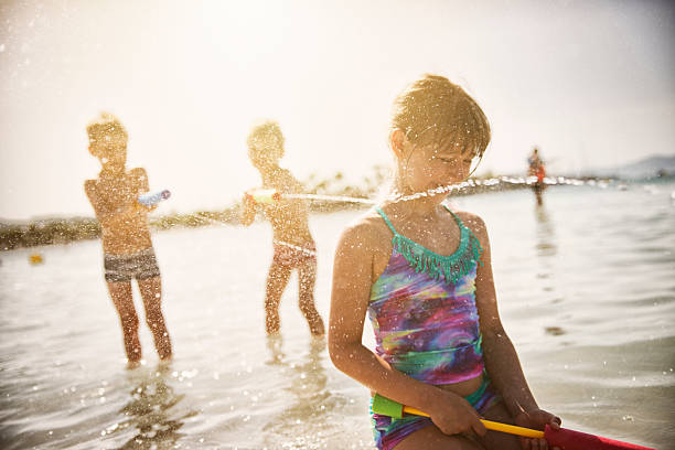 istock Kids playing with water guns at sea 503917641
