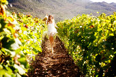 Beautiful woman dances among vines, full of joie de vivre