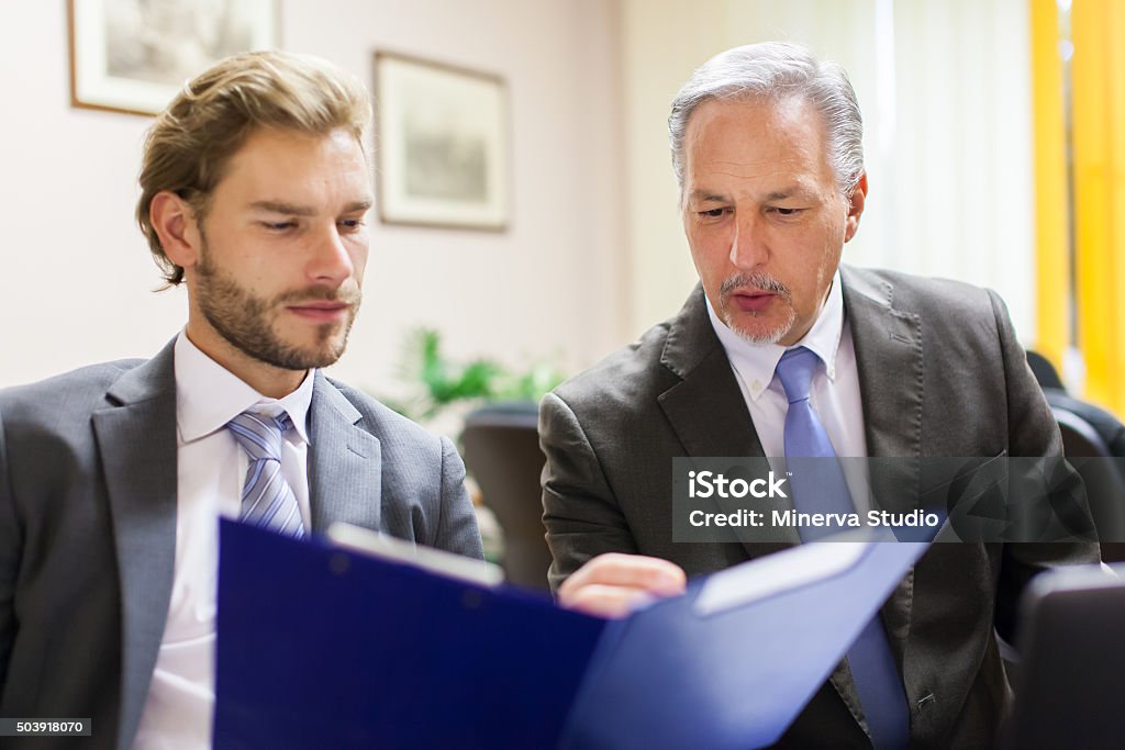 Businessman showing a document to his colleague Active Seniors Stock Photo