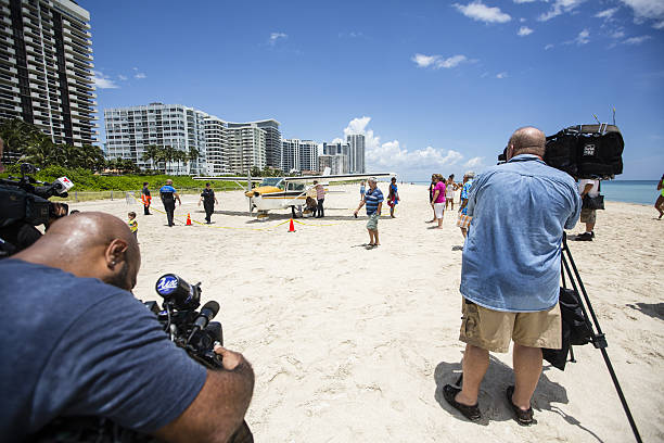 Miami Beach, USA - July 29, 214: A single engine Cessna made an emergency landing on the sands of Miami Beach. New Crews and beach goers are seen here.