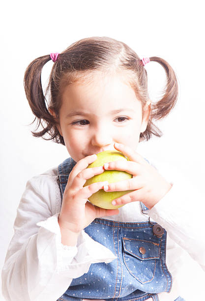 istock Little girl biting a green apple 503920116
