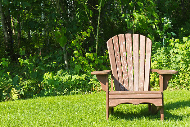 Adirondack summer lawn chair outside on the green grass stock photo