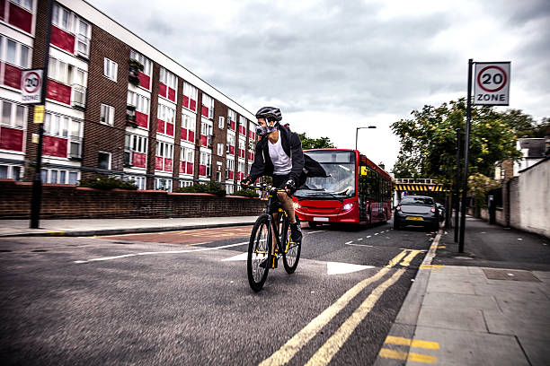 ciclista commuter usando una máscara de contaminación en el centro de londres - hackney fotografías e imágenes de stock