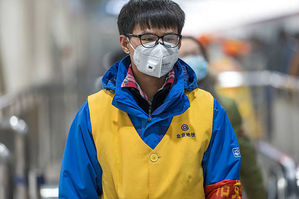 employé portant masque à la bouche de métro avec filtre contre la pollution de l'air - beijing air pollution china smog photos et images de collection