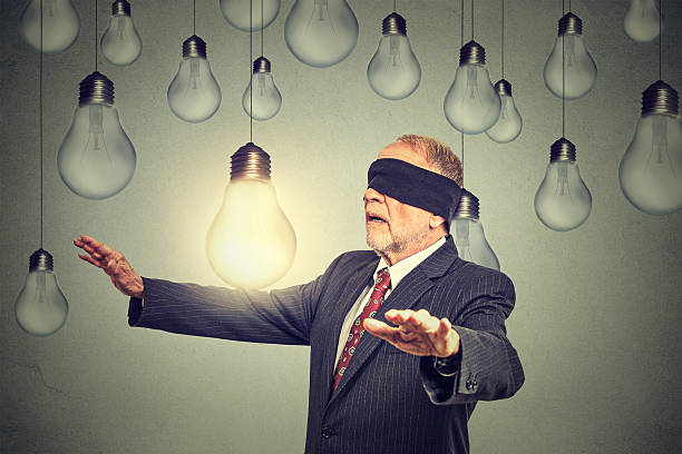 istock Blindfolded man walking through light bulbs searching for bright idea 503920898