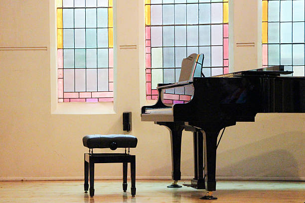Church Piano bathed in stained-glass light stock photo