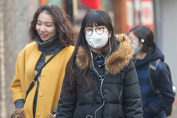 garota usando máscara de boca com filtro contra a poluição atmosférica, beijing - smog china beijing pollution - fotografias e filmes do acervo