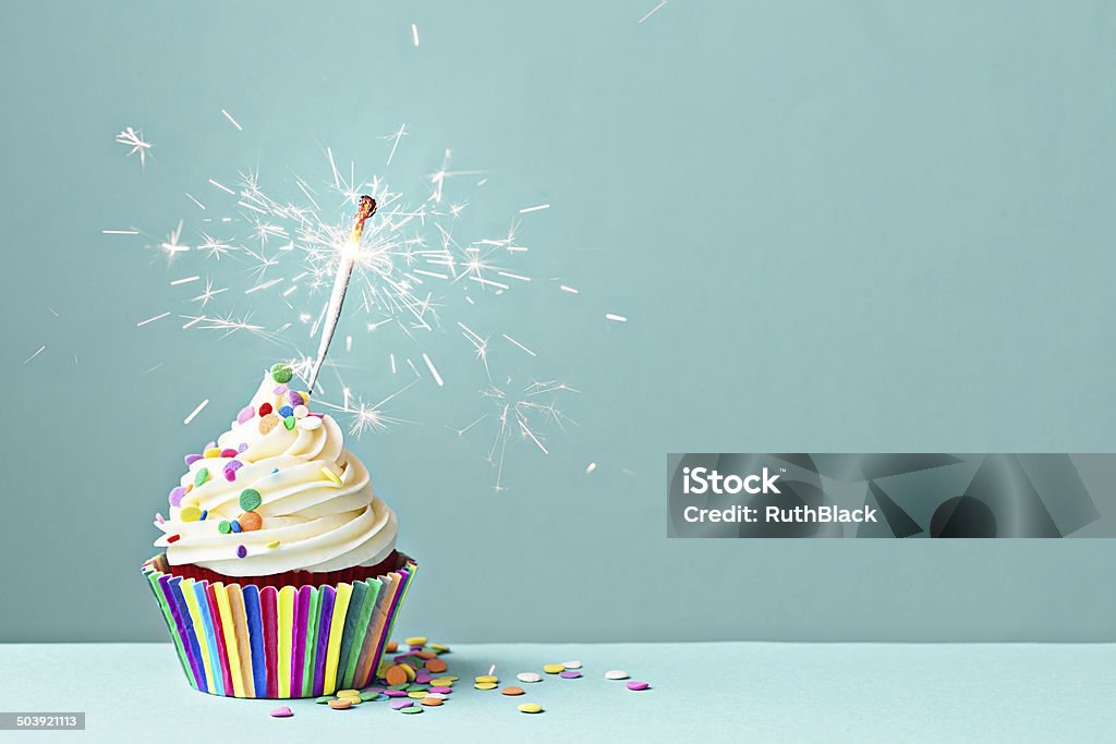 Celebration cupcake with sparkler Cupcake decorated with colorful sprinkles and a sparkler Cupcake Stock Photo