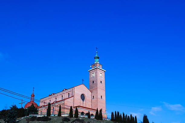Tower and cross of an orthodox church against the blue sky on a sunny day.