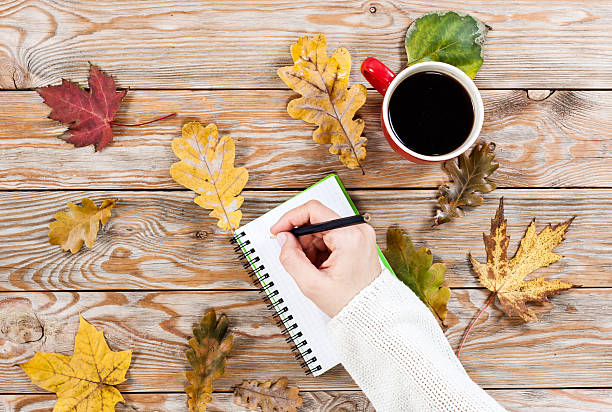 istock Coffee cup, notebook and autumn leaves 503923862