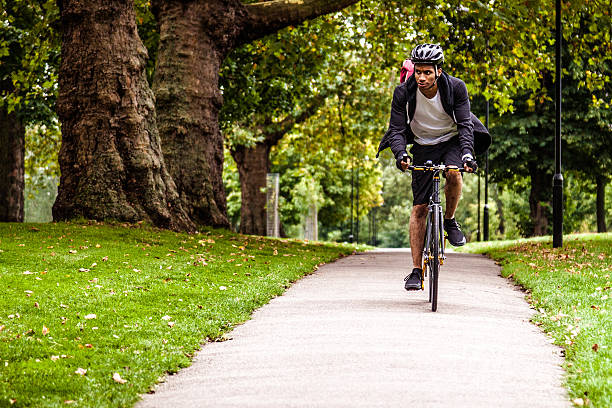 Commuter cycling in the park going at work in London stock photo