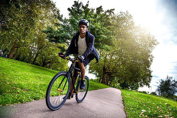 commuter ciclismo en el parque va a trabajar en londres - african descent cycling men bicycle fotografías e imágenes de stock