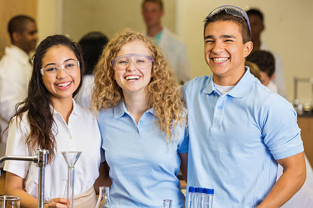 High school students smiling in science chemistry lab