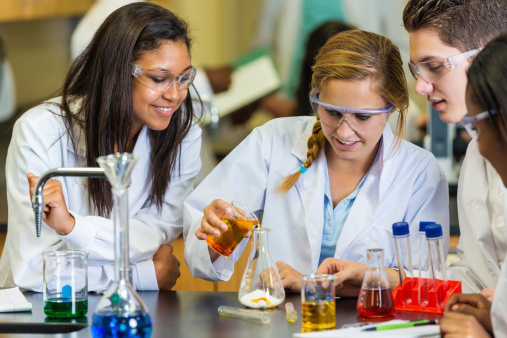 Teens using chemistry set during high school science experiement