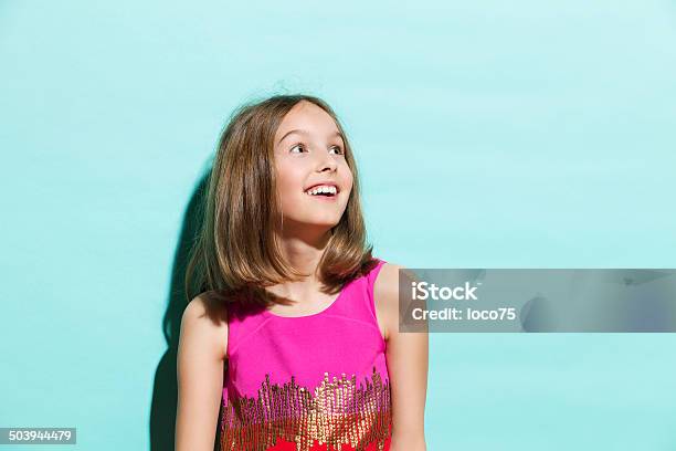Smiling Girl On Turquoise Background Looking Up Stock Photo - Download Image Now - Girls, Teenage Girls, Looking Up