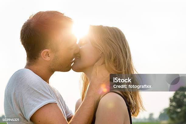 Summer Portrait Of A Kissing Young Adult Couple Back Lit Stock Photo - Download Image Now