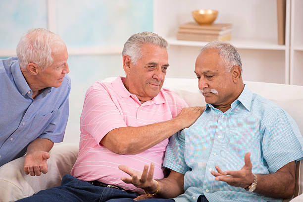 istock Diverse group of senior men console a friend. Home setting. 503947047