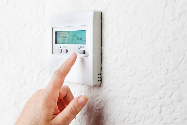 Conserving Energy by Controlling Indoor Temperature Subject: Controlling temperature to conserve energy power consumption. adjusting stock pictures, royalty-free photos & images