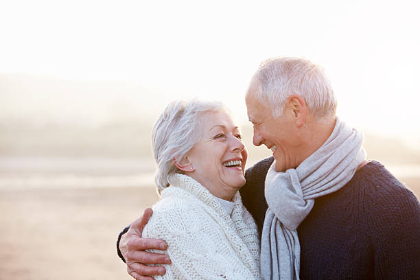 romantisches altes paar auf den strand - couple winter expressing positivity loving stock-fotos und bilder