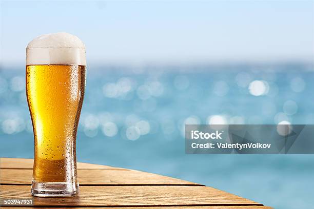 Birra In Vetro Su Sfondo Sfocato Di Mare - Fotografie stock e altre immagini di Birra - Birra, Spiaggia, Estate