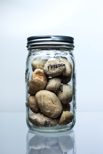 Glass jar containing a group of pebbles.