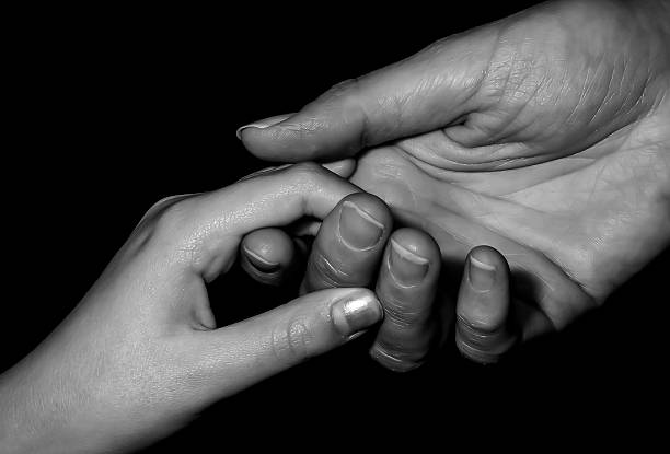 istock mother holding child's hand, black and white image. 503948143