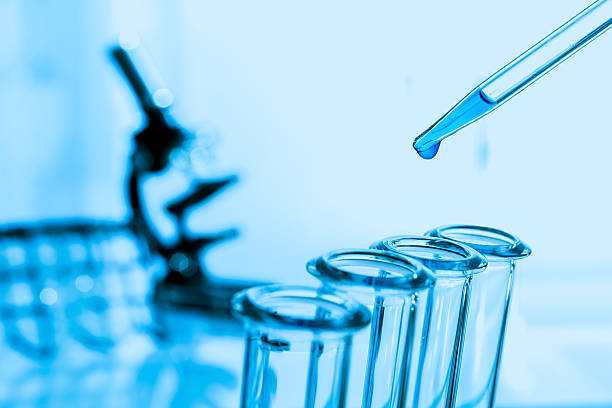 Pipette adding fluid to one of several test tubes .medical stock photo