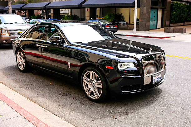 Black 2015 Rolls Royce Ghost sedan Beverly Hills, CA, USA - July 1, 2015: Black 2015 Rolls Royce Ghost sedan vehicle in downtown Beverly Hills California (Note: License Plate is fake) Rolls-Royce La Rose Noire Droptail: stock pictures, royalty-free photos & images