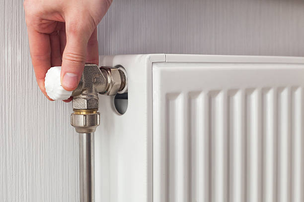 istock Radiator adjustment closeup. Man's hand adjusting radiator temperature. 503952112
