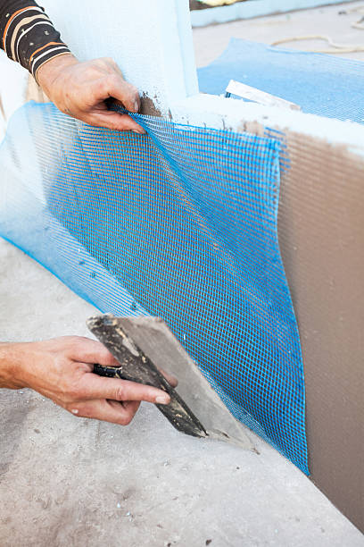 istock Worker spreading mortar over styrofoam insulation with trowel 503952742