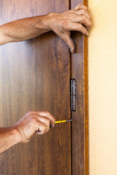 istock Front door installation. Worker fastens door trims with screwdriver 503952768