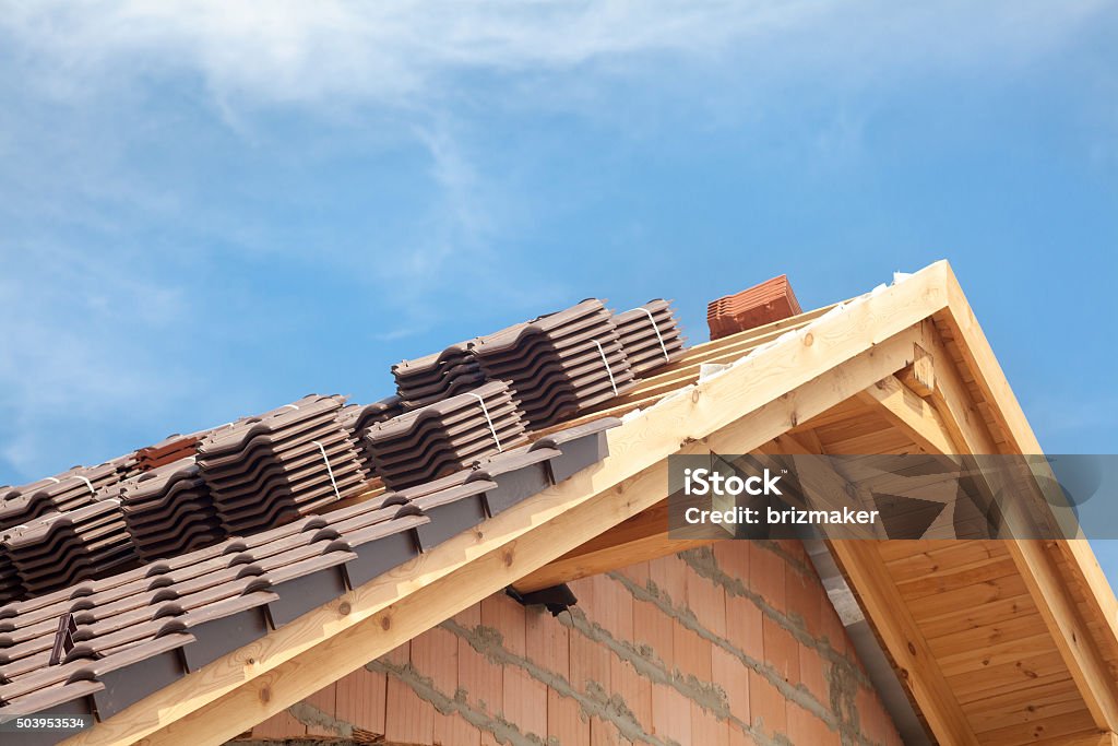 House under construction. Roofing tiles preparing to Install Rooftop Stock Photo