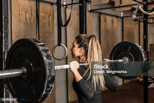 Giovane Atleta Femminile Eseguire Squat In Palestra - Fotografie stock e altre immagini di Cross training