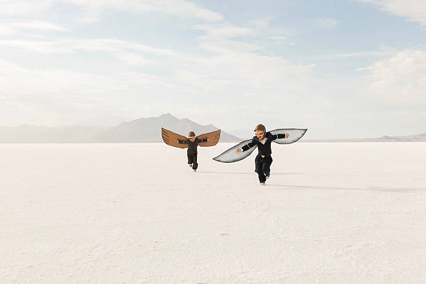 young business jungen trägt pappe wings fliegen - taking off business creativity adventure stock-fotos und bilder