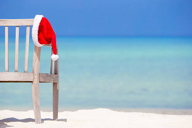 istock Christmas concept. Red santa hat at tropical white beach. 503955820