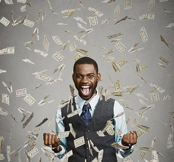 happy man pumping fists celebrates success under money rain Portrait happy man exults pumping fists ecstatic celebrates success screaming under money rain falling down dollar bills banknotes isolated gray background with copy space. Financial freedom concept free bingo stock pictures, royalty-free photos & images