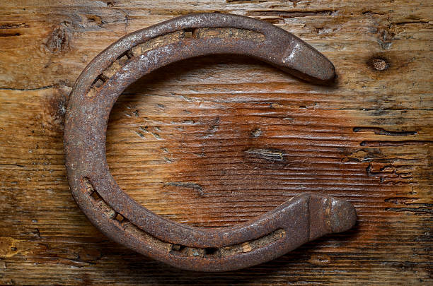 istock rusty horse shoe on wood table shaped like letter c 503958210