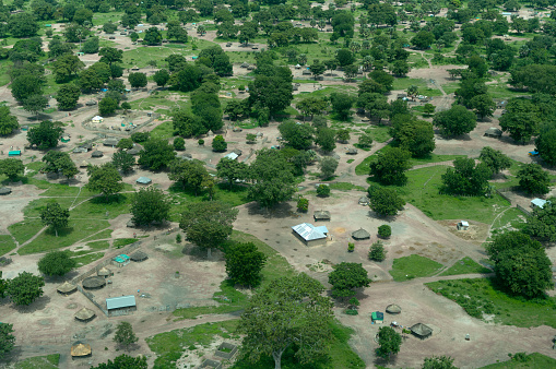 Aerial view of a residential area and highway road at Austin, Texas. There are large houses with trees outside and a view of a straight highway on the left with few vehicles passing.