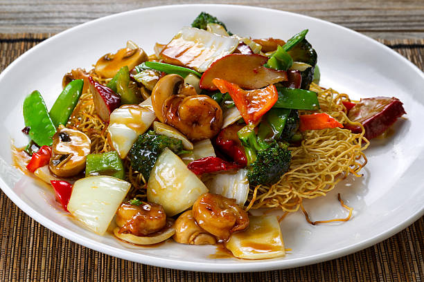 Fried noodle with shrimp and vegetables in sauce Close up front view of a fried noodle with shrimp, pork, vegetables and sauce in white plate. chinese food photos stock pictures, royalty-free photos & images