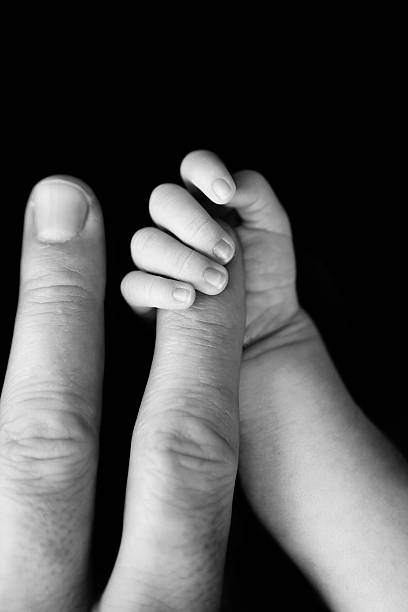 istock Newborn Gripping Dad's Finger 503978562