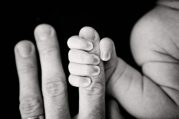 istock Newborn Gripping Dad's Finger 503978752