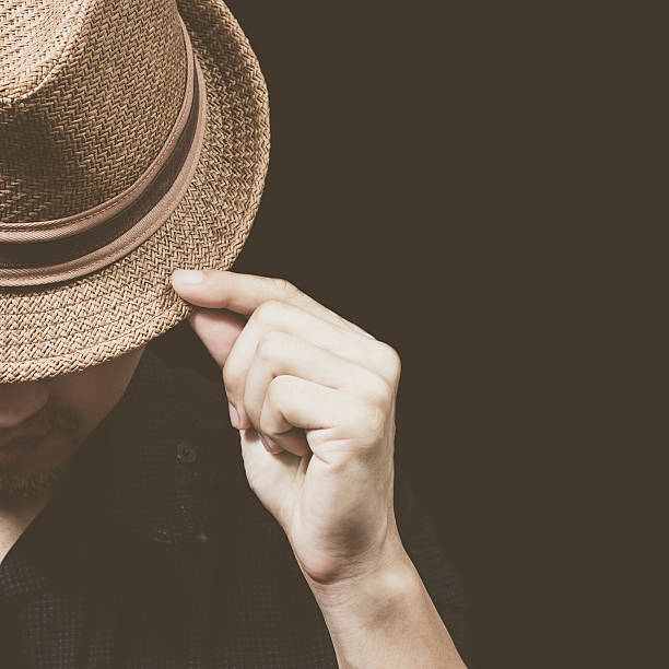 istock asian man in black shirt touching hat, isolated on black 503984070