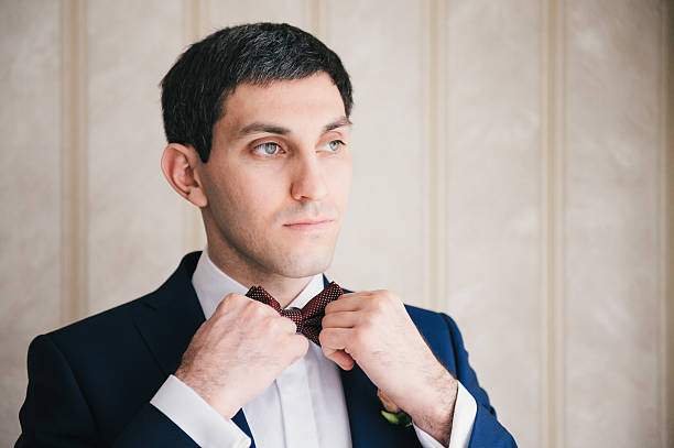 istock man straightens his tie before  wedding 503985836
