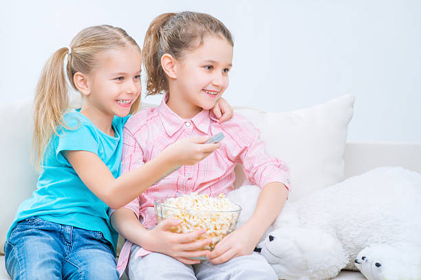 istock Cheerful little sisters sitting on the sofa 503991040