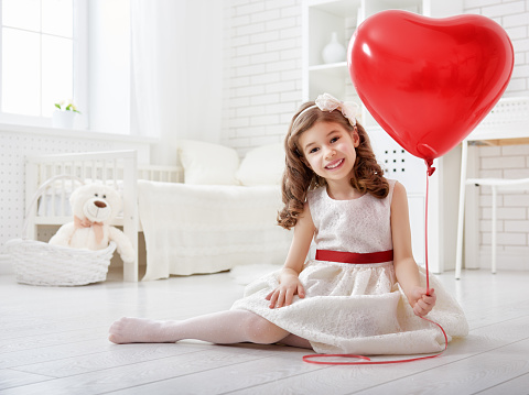 Happy Valentine's Day! Sweet child girl with red heart.