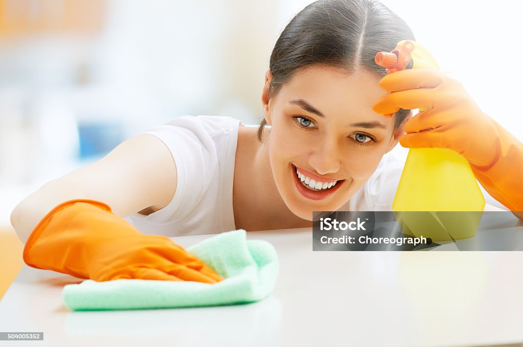 housewife beautiful girl cleans the surface Adult Stock Photo