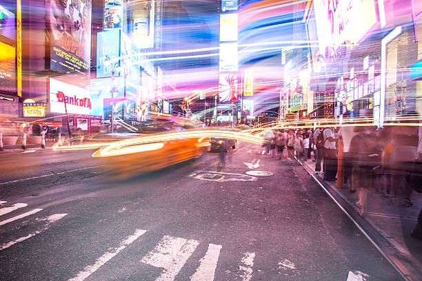New York City, USA - August 9, 2019:People and tourists stroll among the lights and skyscrapers of Time Square in Manhattan during a summer night