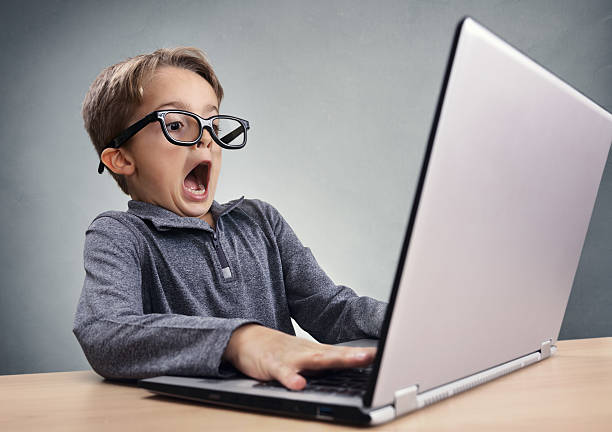 scioccato e sorpreso ragazzo su internet con computer portatile - little boys shock surprise human mouth foto e immagini stock