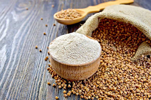 istock Flour buckwheat in bowl and spoon with cereals on board 504010536