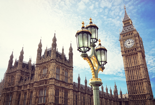 Big Ben in London with the houses of parliament and ornate street lamp